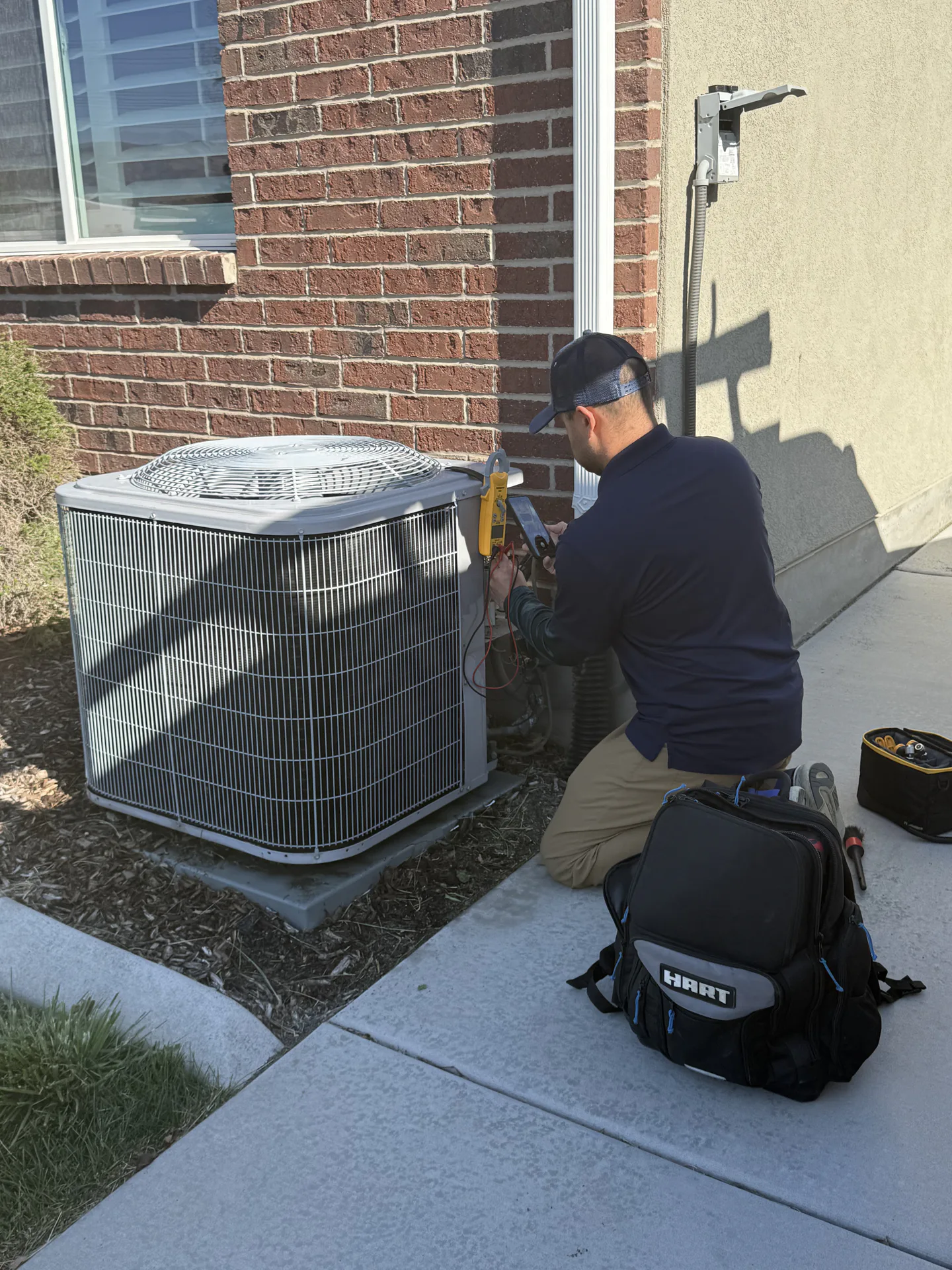 AYSP technician servicing a Goodman AC condenser